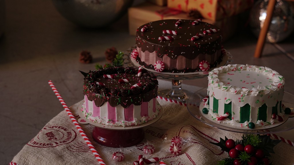 Tri ukrašene novogodišnje torte na dekorisanom stolu